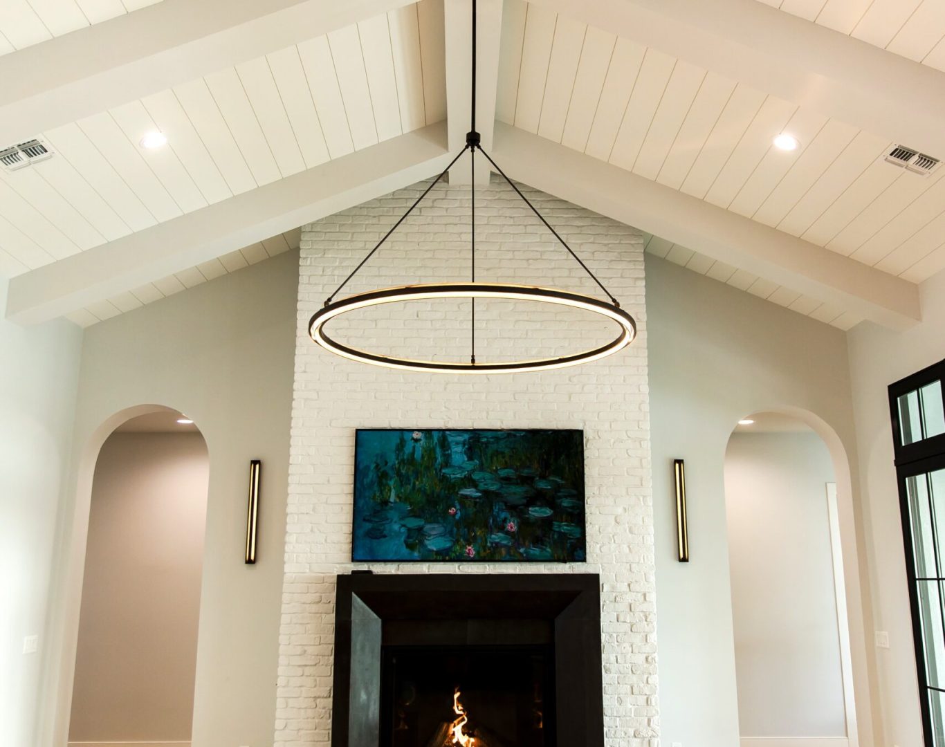 Kowalski Painting team prepping and taping off trim before painting in a Phoenix living room, Painter applying lime wash finish to an elegant Paradise Valley fireplace wall